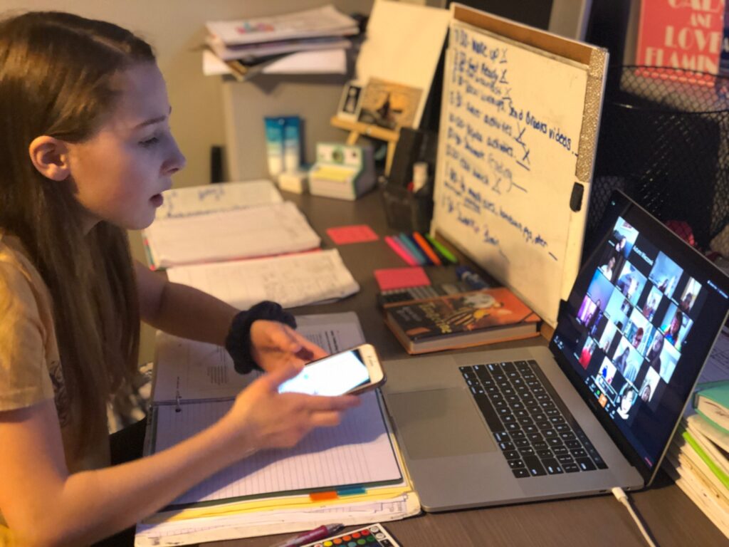 Teenage girl at home on a zoom call with her teacher and class.