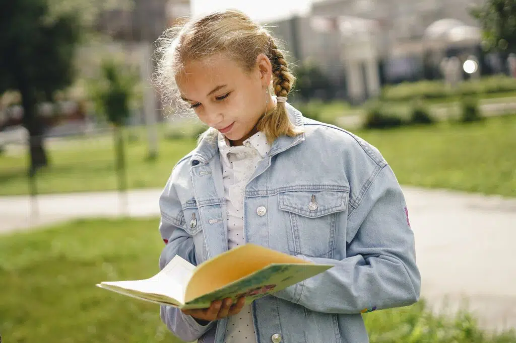 Young school girl with school diary outdoor